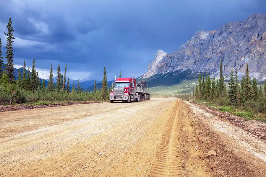 Large red tractor trailer on the Dalton Highway, a 414 mile gravel and dirt road