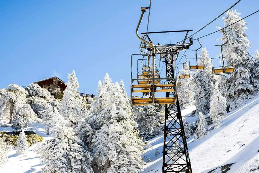 Snow covered trees and ski lift to mountain summit