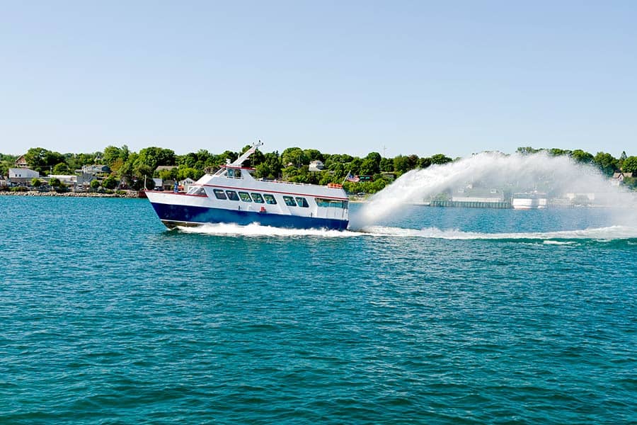 Ferry boat crosses the blue water of Lake Michigan taking tourists to island