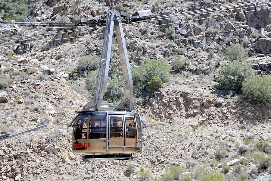 Tramway carries tourists up rugged mountain high above the ground