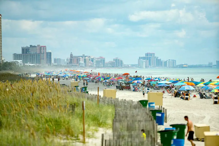 People crowded onto beach, ocean and resort hotels in background